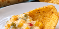 Creamy cheesy corn and green chile dip served warm with corn chips